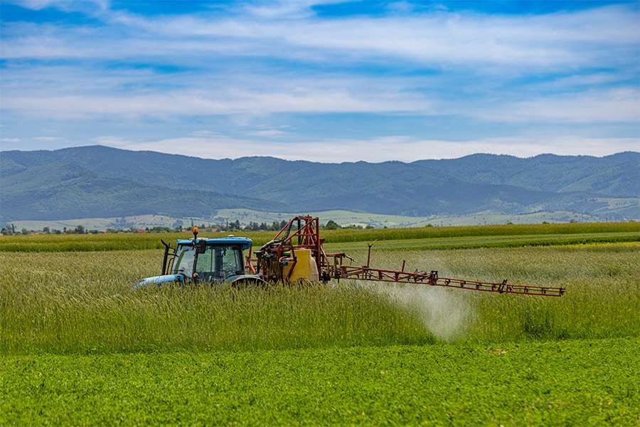 tractor spreading synthetic fertiliser on field